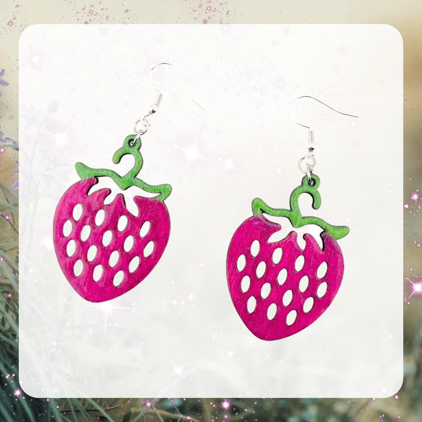This is an image of a pair of laser cut wood raspberry shaped earrings that have been painted pink and with green stems.