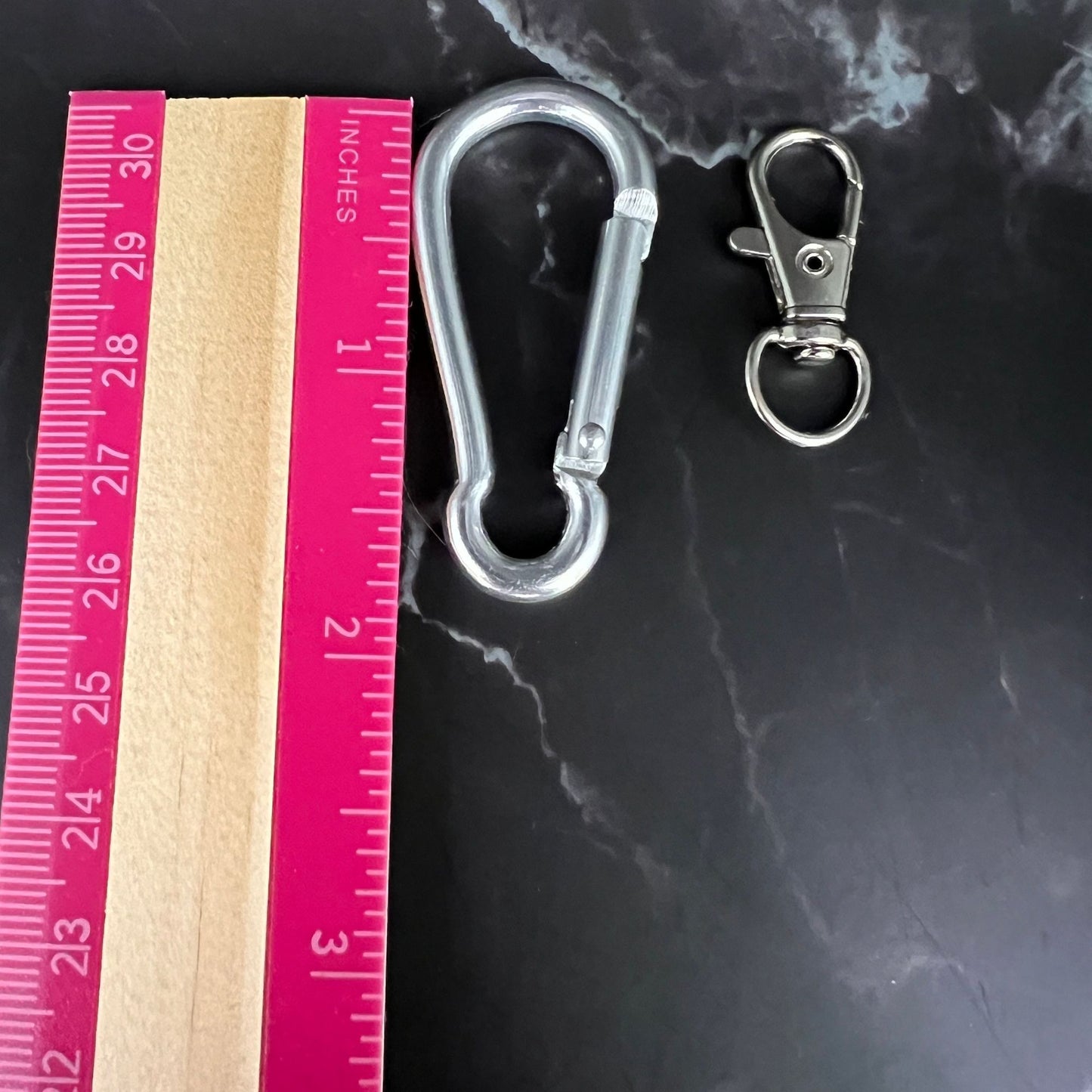 The 1.75" carabine clip compared to the 1.25" swivel clip, displayed next to a ruler.