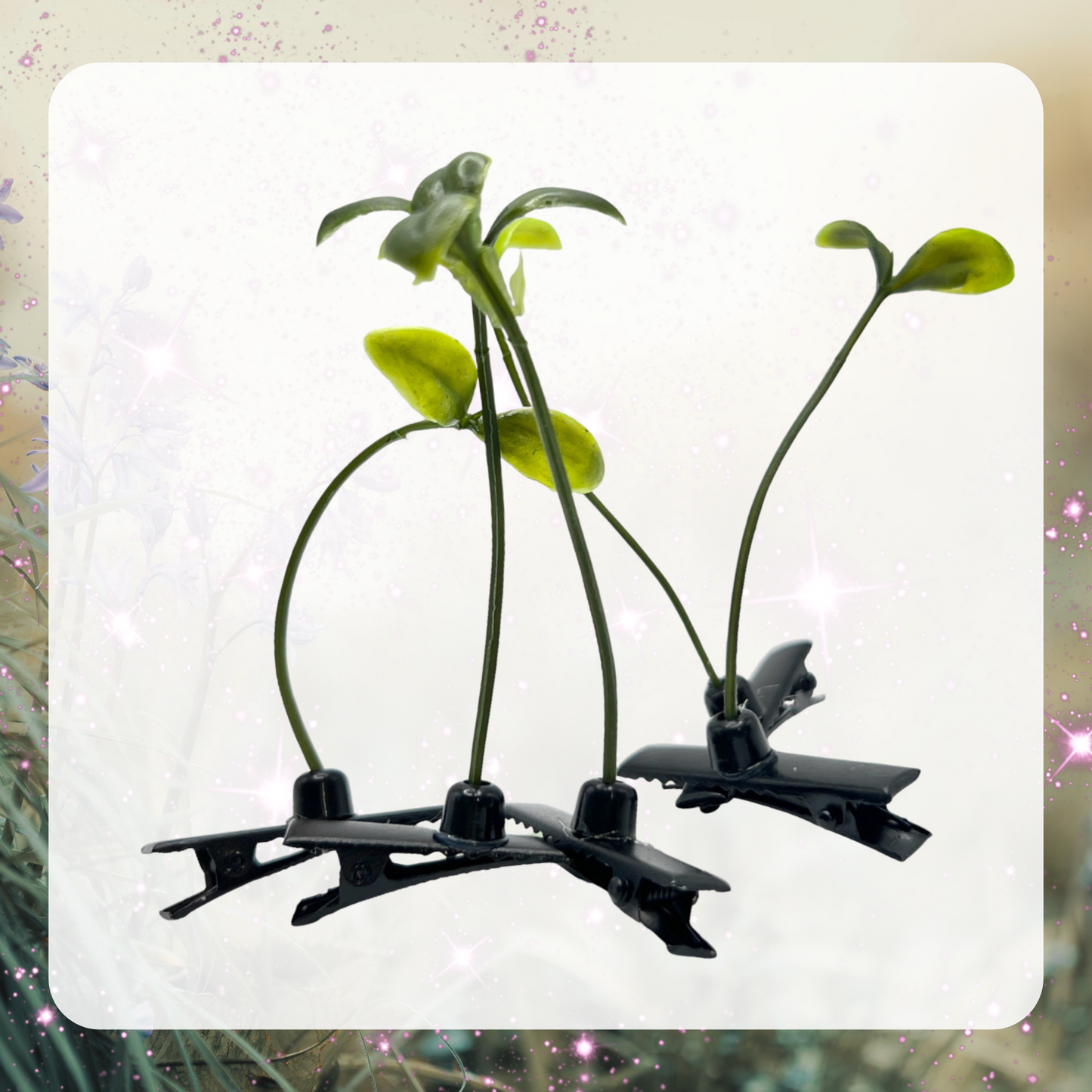 Picture shows five bean sprout hair clips. Each clip has a black alligator clip and a green plant with two leaves.
