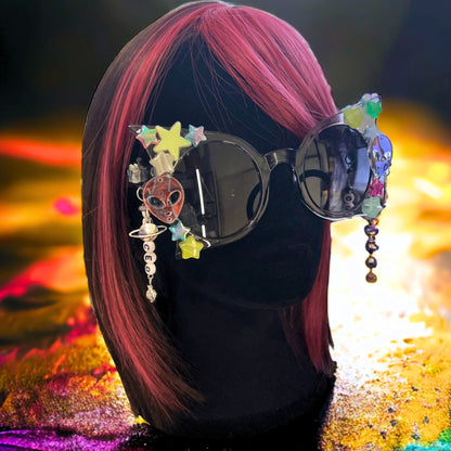 Hypnotic Space Alien Sunglasses with glow-in-the-dark stars and alien charms for a cosmic rave experience! Displayed on a mannequin.