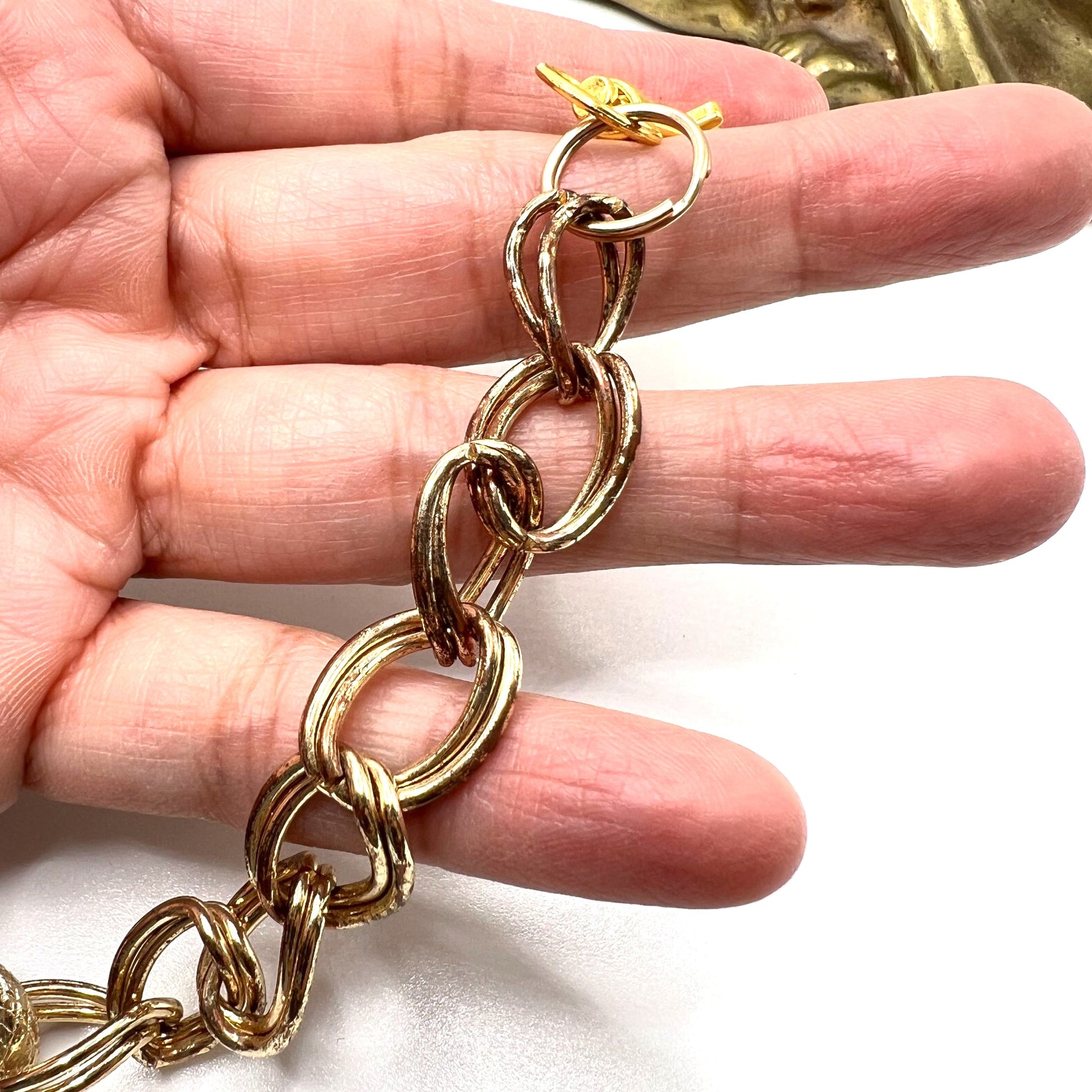 Close-up of Pink Wallet Chain – versatile vintage upcycled jewelry. Displays a close-up of the tarnished gold chain. 