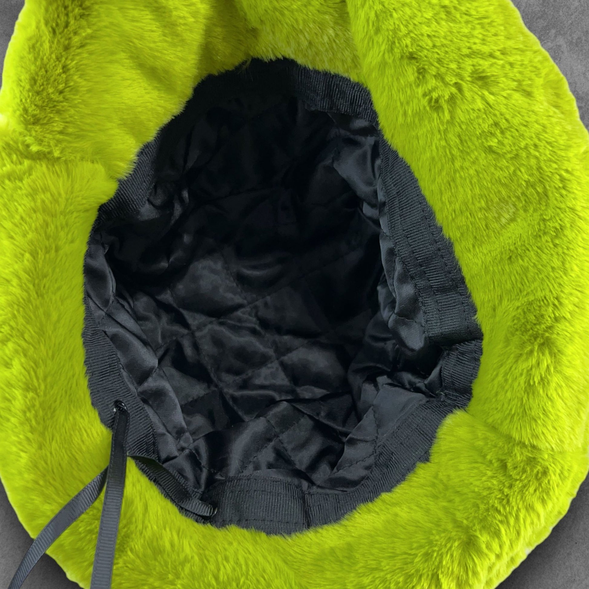 Luck of the Irish Green Furry Festival Bucket Hat – Vibrant and festive accessory for standing out at festivals and events! Displayed on a table. Inside view.