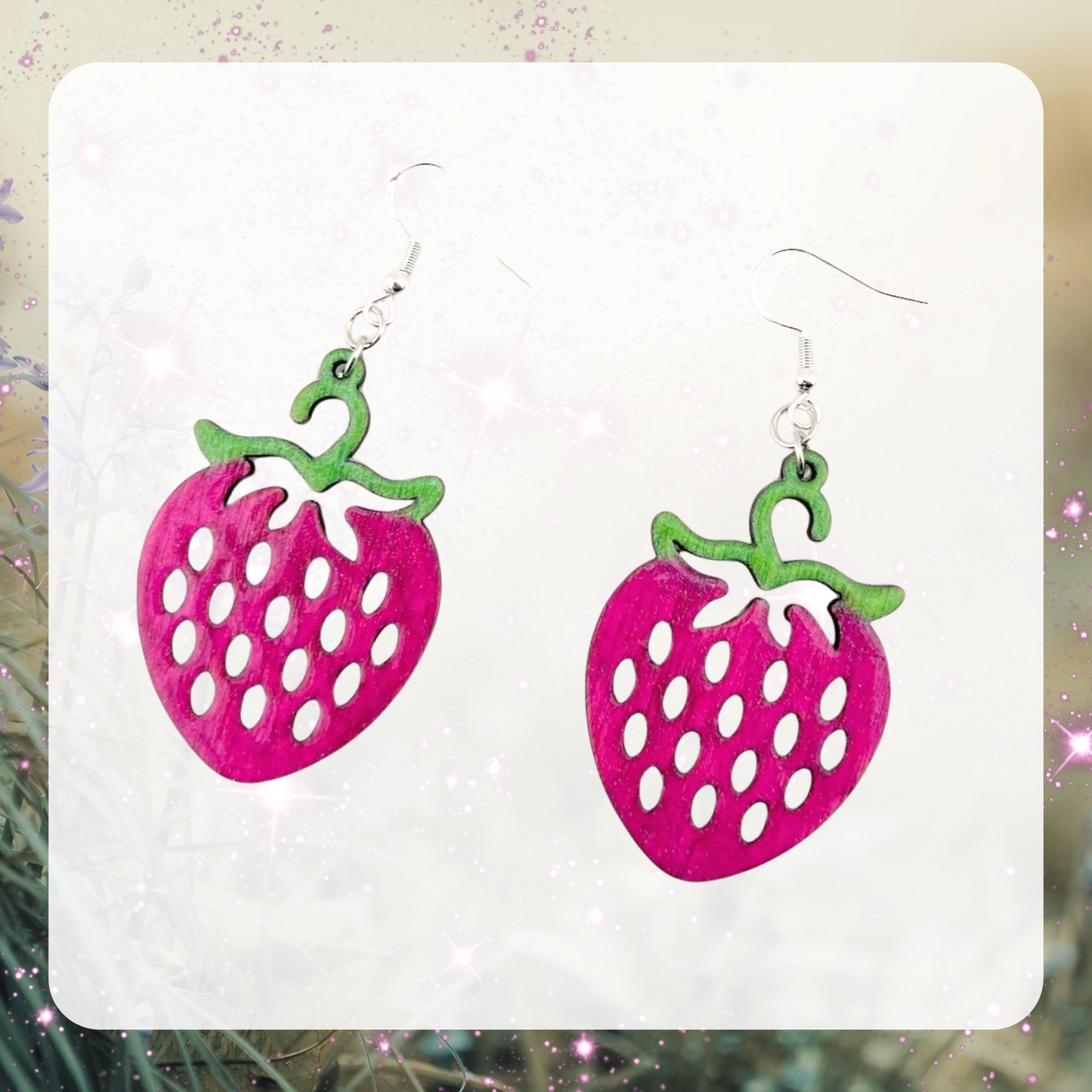 This is an image of a pair of laser cut wood raspberry shaped earrings that have been painted pink and with green stems. 