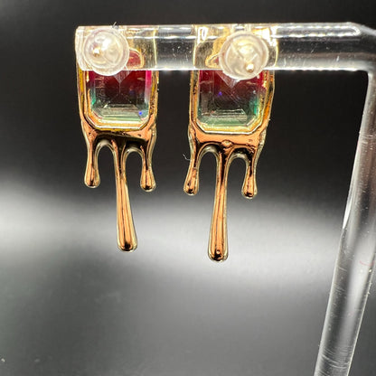 Gold metal earrings with melted design and large pink/green imitation watermelon tourmaline stones. Displayed on a clear stand. Showing the back view.