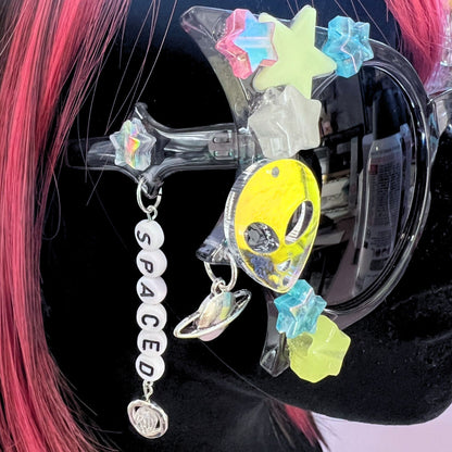 Hypnotic Space Alien Sunglasses with glow-in-the-dark stars and alien charms for a cosmic rave experience! Displayed on a mannequin. Side view.