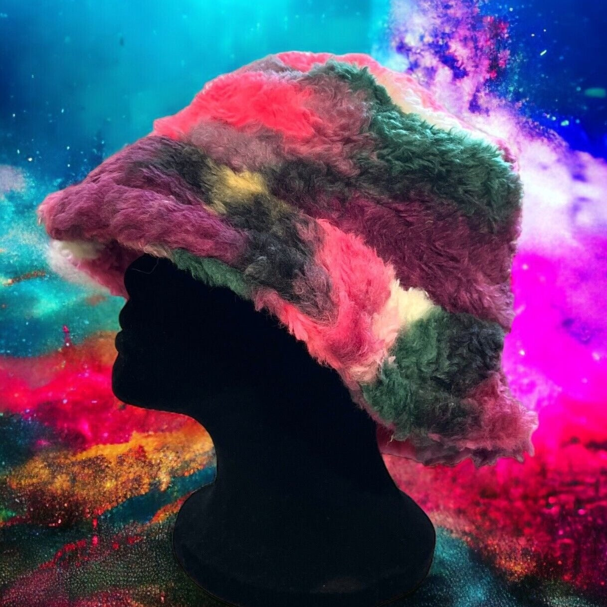 Colorful tie-dye faux fur bucket hat with adjustable drawstring. Soft and cozy for a statement look at festivals and raves. Unisex design. Displayed on a mannequin.