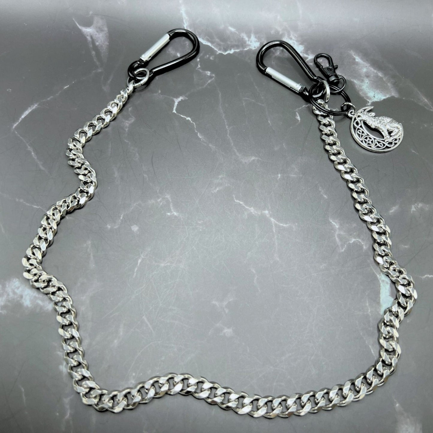 Durable stainless steel wallet chain with customizable clips and wolf keychain. Displayed on a table.