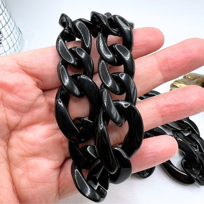 Handmade black acrylic chain with carabiner clips. Close up of the chain links.