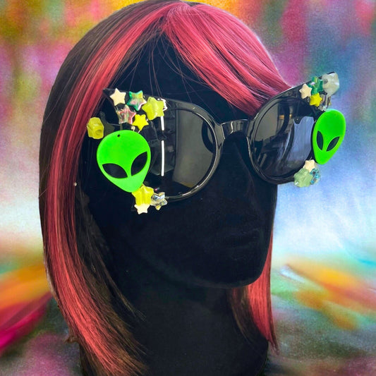 Glow-in-the-dark star festival sunglasses for an out-of-this-world look. Displayed on a mannequin.
