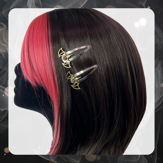 Pictures shows a black velvet mannequin head that has brown hair with the front bangs and sides being pink hair. The mannequin displays two bronze metal bat hair clips that use silver snap hair clips. 