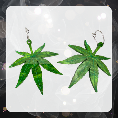 A pair of green glitter marijuana leaf earrings. They are large, about 2” long and made from laser cut acrylic, lightweight plastic. 