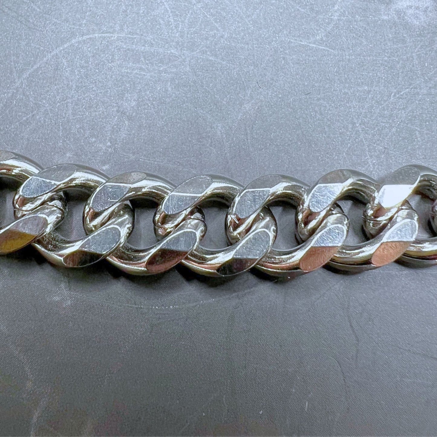 Durable stainless steel wallet chain with customizable clips and wolf keychain. Displayed on a table. Close up of the diagonal Cuban link chain.