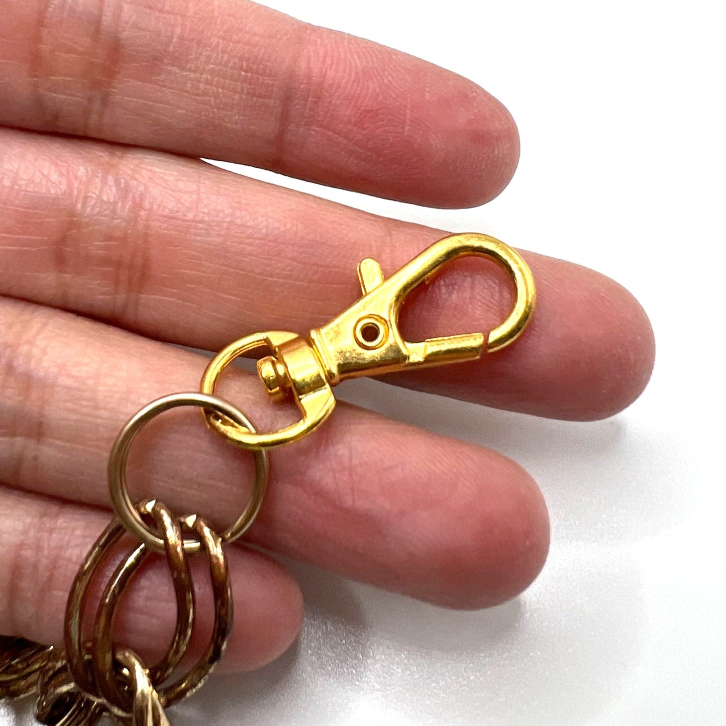 Close-up of Pink Wallet Chain – versatile vintage upcycled jewelry. Displays a close-up of the gold swivel clips. 