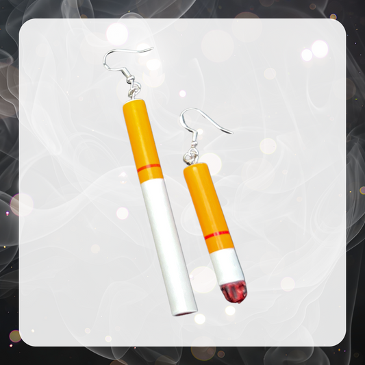 The picture shows a pair of cigarette charm earrings. The pair is mismatched with one earring being a full unlit fake cigarettes and the other being a half smoked lit cigarette. 