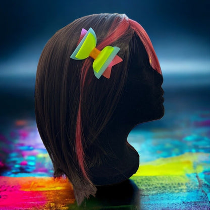 Neon bow tie hair clips displayed on a mannequin.