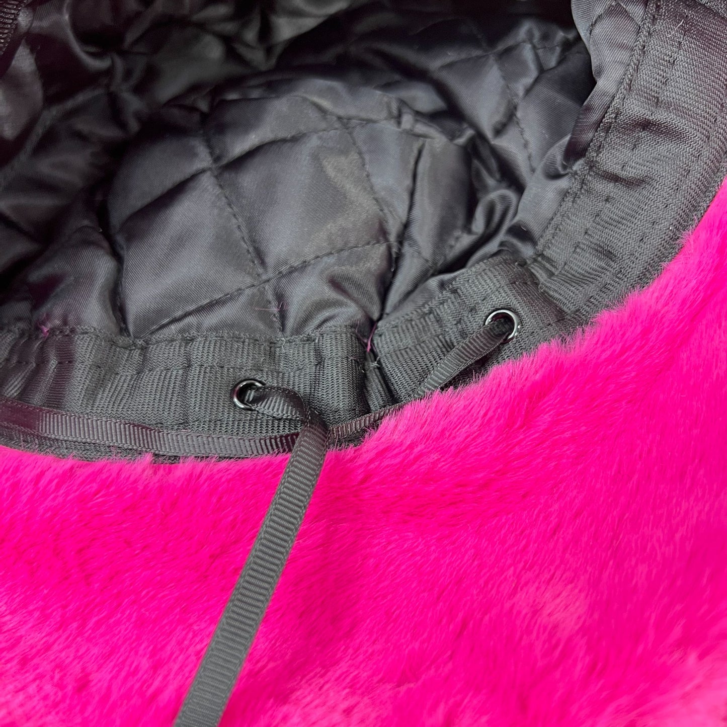 Sassy "That's Hot" Pink Furry Festival Bucket Hat – a vibrant accessory for making a bold fashion statement at any event! Displayed on a table. Drawstring view.