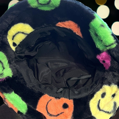 Black faux fur bucket hat with a colorful smiley face design. Soft and cozy for a joyful festival look. Adjustable drawstring. Unisex for men or women. Showing the inside of the hat.