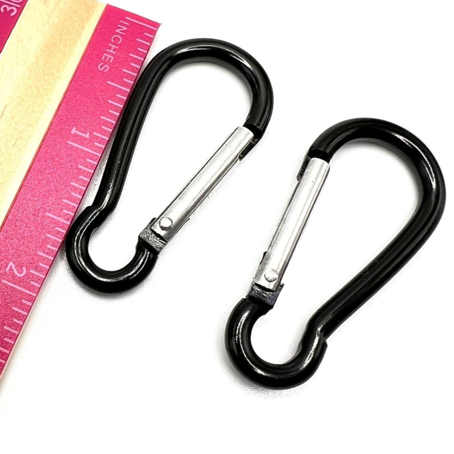 Handmade black acrylic chain with carabiner clips. Displayed on a table with a ruler showing the carabiner length as 1.5".