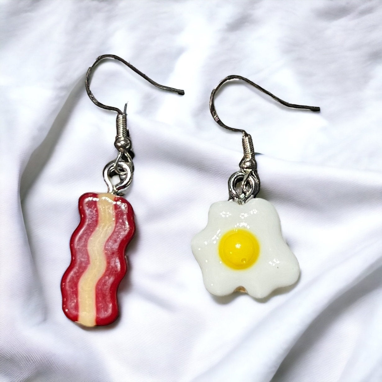 Close-up of Brunch Mini Food Earrings featuring cute Bacon and Eggs charms. Quirky and delightful accessories for foodie fashion.